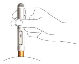 A hand holding a cylindrical pen-shaped medical device vertically, placing it against the curved surface of a body part