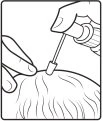 Una mano tiene un flacone contagocce e applica una goccia di liquido sulla superficie della pelle di una testa con capelli ondulati