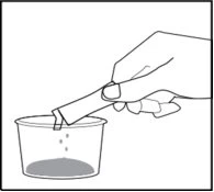 A hand holds a pipette pouring drops of liquid into