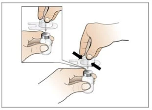 Due mani che utilizzano un dispositivo di pressione per premere un cappuccio trasparente su un flaconcino di vetro per estrarre il farmaco