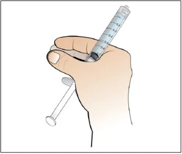 Una mano tiene saldamente una siringa graduata con lo stantuffo estraibile per la preparazione di un
