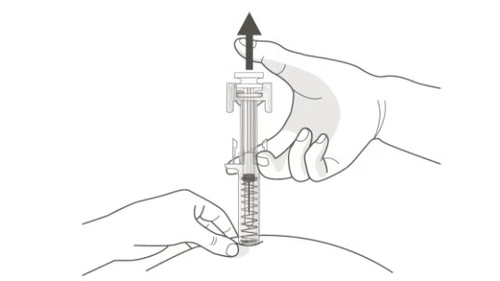 Una mano tiene la parte superiore di un dispositivo medico mentre l'altra spinge il pistone per somministrare il farmaco