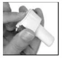 One hand holds and opens a white medical vial to extract its contents using an administration device
