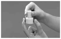 Two hands hold and manipulate a small cylindrical medical vial with a white cap on a neutral gray background
