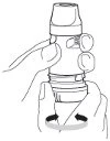 A hand holding a cylindrical medical device while the