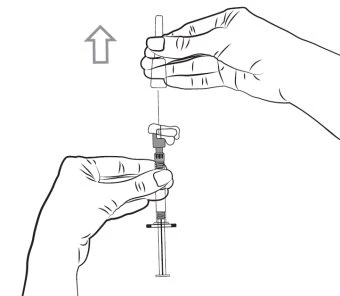 A hand holding the upper part of a syringe while