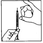 A hand holds a syringe vertically while the