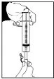 Technical illustration showing a hand holding a syringe with the