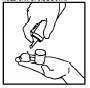 A hand holding an open vial while the