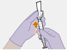 Gloved hands drawing the contents of a vial into a syringe with an orange arrow indicating upward movement