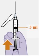 A hand holding a syringe with the needle pointing upward...