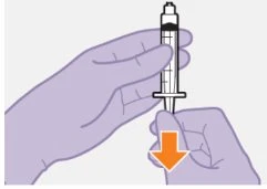 A hand holds a syringe vertically containing dark liquid while another hand...