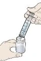Una mano tiene una siringa con ago inserito nel tappo di un flaconcino di vetro mentre l'altro capo della siringa è aperto