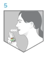 Side view of a woman holding an inhaler near her mouth with an arrow indicating inhalation