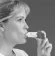 Profile of a woman holding an open sachet near her mouth, ready to take the powdered medication