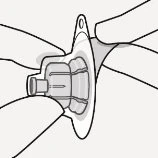 Two hands holding and positioning a circular medical device with a flat base and a raised central structure for an 'l'