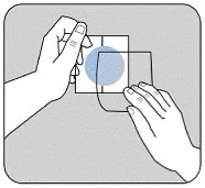 Two hands handling two overlapping transparent sheets with a central blue circle against a neutral gray background