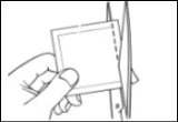 A hand holds a square pouch while a pair of scissors cuts the right side to open it