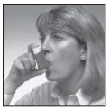 A woman with light hair holding an inhaler close to her mouth, ready to use it for the