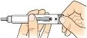 Two hands hold a white cylindrical medical device for administration