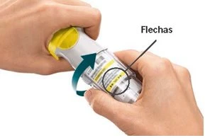 Due mani tengono un dispositivo medico bianco e giallo ruotandolo in senso orario come indicato da una freccia curva blu e dalla scritta Flechas