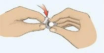 Two hands holding and pressing a white medical device with a red arrow indicating downward pressure movement