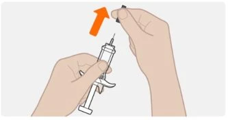 Two hands preparing a syringe, one holding the syringe barrel and the other