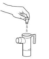 A hand holding an inverted bottle to dispense liquid drops