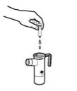 Una mano tiene una fiala sopra un dispositivo medico cilindrico da cui cadono gocce di liquido