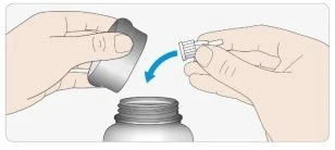 Due mani che inseriscono un tappo bianco con un piccolo beccuccio all'interno di un dispositivo medico