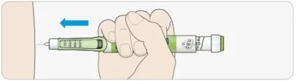 A hand holding a green and white injection pen to administer the