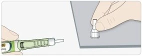 A hand holding a green and white medical device while the