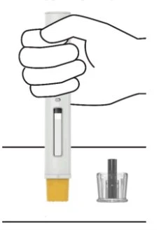 A hand holding a white cylindrical medical device with a transparent indicator next to a separate transparent protective cap