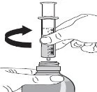 A hand rotating a syringe with liquid over the neck of a medicine bottle held by another hand