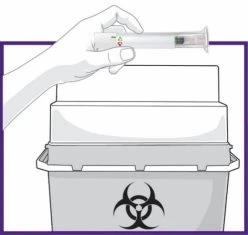 Una mano tiene una siringa sopra un contenitore per rifiuti biologici con il simbolo del rischio biologico nero su fondo bianco