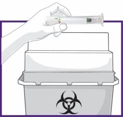 Una mano tiene una siringa sopra un contenitore per lo smaltimento di rifiuti biologici con il simbolo del rischio biologico nero