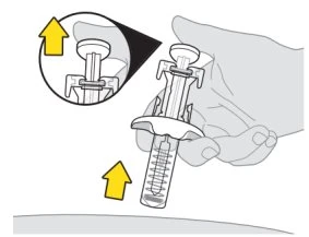 A hand holds a syringe ready for