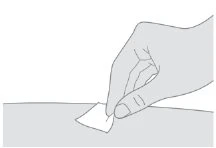 A hand holds a small piece of paper or a bandage on a flat horizontal surface in a stylized black-and-white drawing