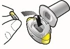 A hand inserts a yellow and white capsule into