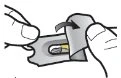 Two hands gently lifting the flap of a metallic package to reveal a yellow and white capsule inside