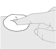 A finger firmly pressing on a circular area of skin to apply or test a medical product