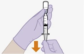 Two gloved hands holding a syringe connected to a vial while an orange arrow indicates the downward movement to aspirate the liquid