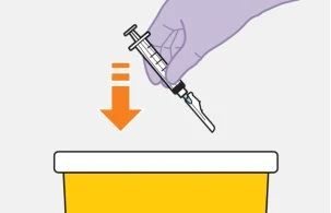 A hand holding a syringe with needle pointing downward above a yellow container with a white lid indicated by an orange arrow