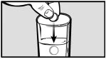 A hand inserting a capsule into a