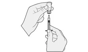 Due mani preparano una siringa con ago inserito in un piccolo flacone di vetro per aspirare il contenuto del farmaco