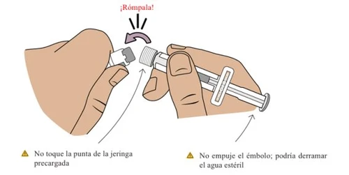 Due mani che spezzano una siringa precaricata per separare la punta dal corpo del dispositivo con una freccia curva che indica il movimento