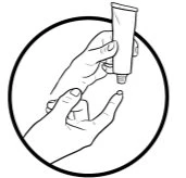Due mani aprono un tubetto di crema premendolo delicatamente per far uscire il prodotto dalla bocchetta all'interno di un cerchio nero