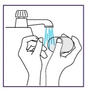 Due mani lavano una saponetta sotto il getto d'acqua