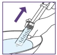 Una mano impugna una siringa con liquido e la immerge in una ciotola d'acqua