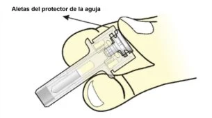 Technical illustration of a hand holding a medical device with an arrow indicating the wings of the needle shield